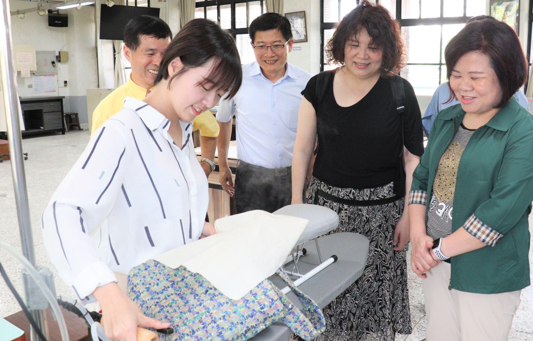 3勞動部長許銘春(右1)雲嘉南分署長劉邦棟(右3)等人訪視服創國手柯宥萱(左1),柯宥萱現場製作手作包