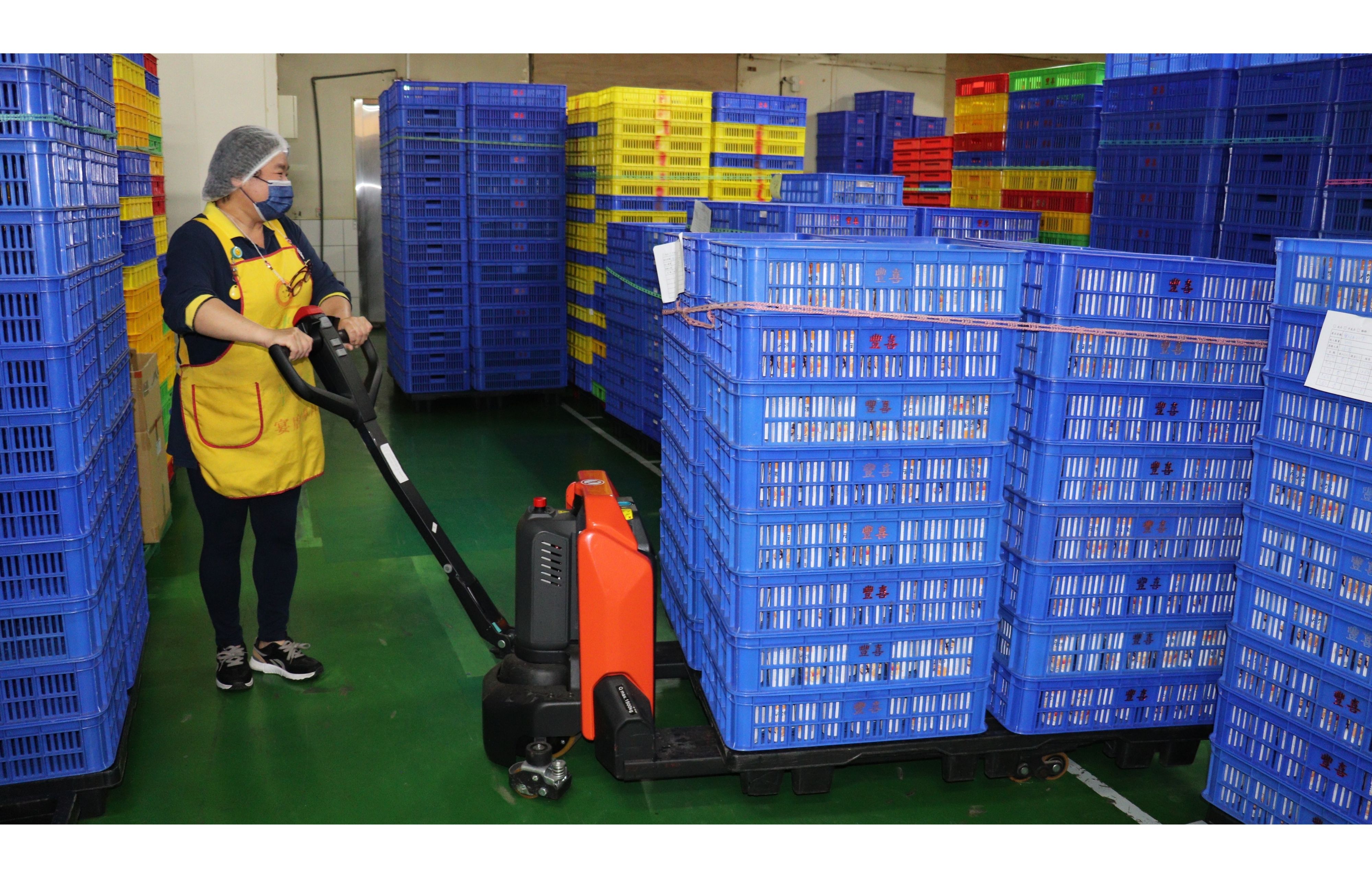 資深員工李姐每天都要拖拉數次近600公斤的果凍成品，自從公司導入電動拖板車後，大讚非常省力，每天工作都笑瞇瞇！