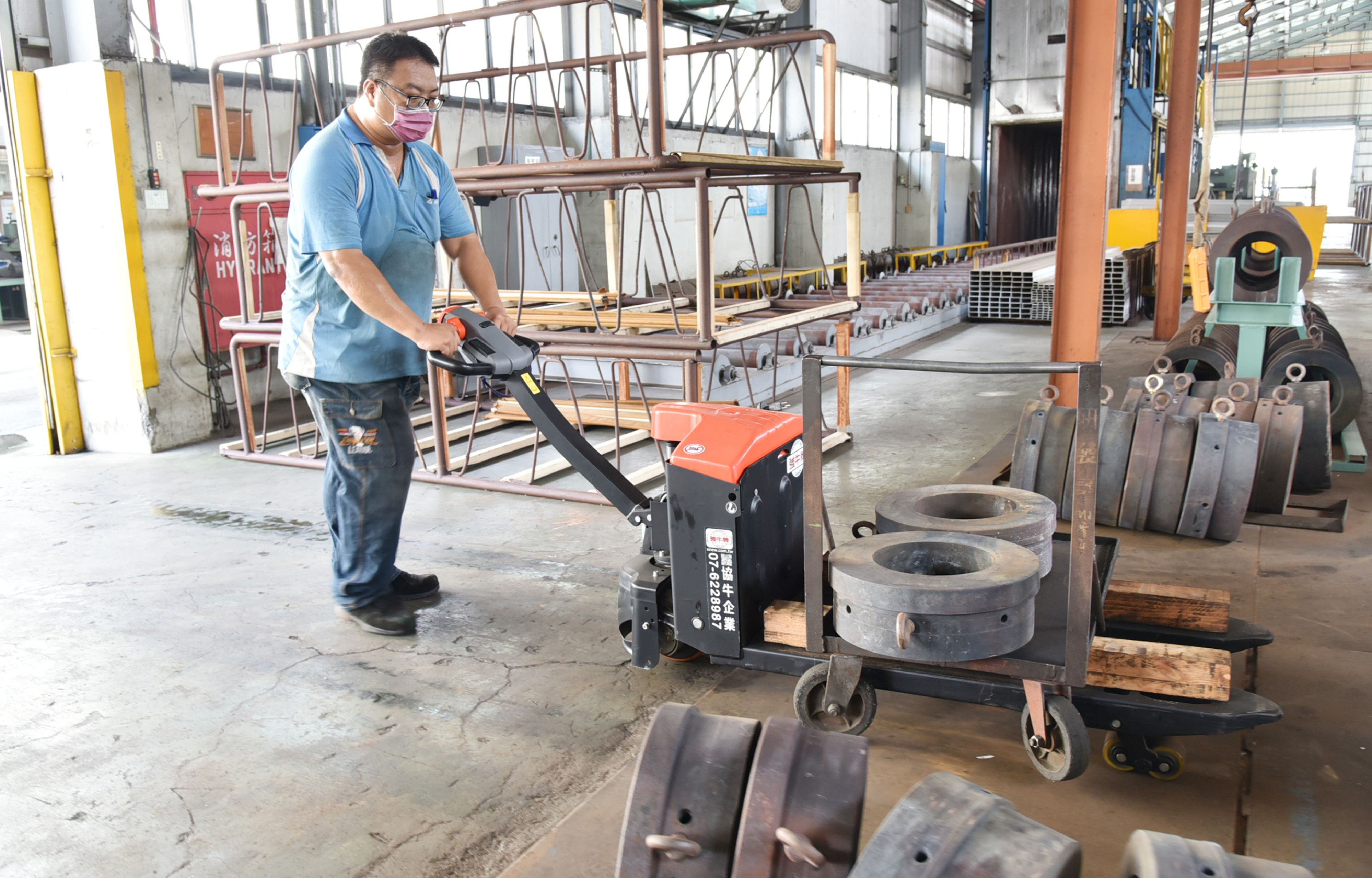 東信輕金屬導入職務再設計方案，添購省力裝置與輔具，要讓中高齡勞工續留職場，圖為中高齡員工操作電動拖板車。1