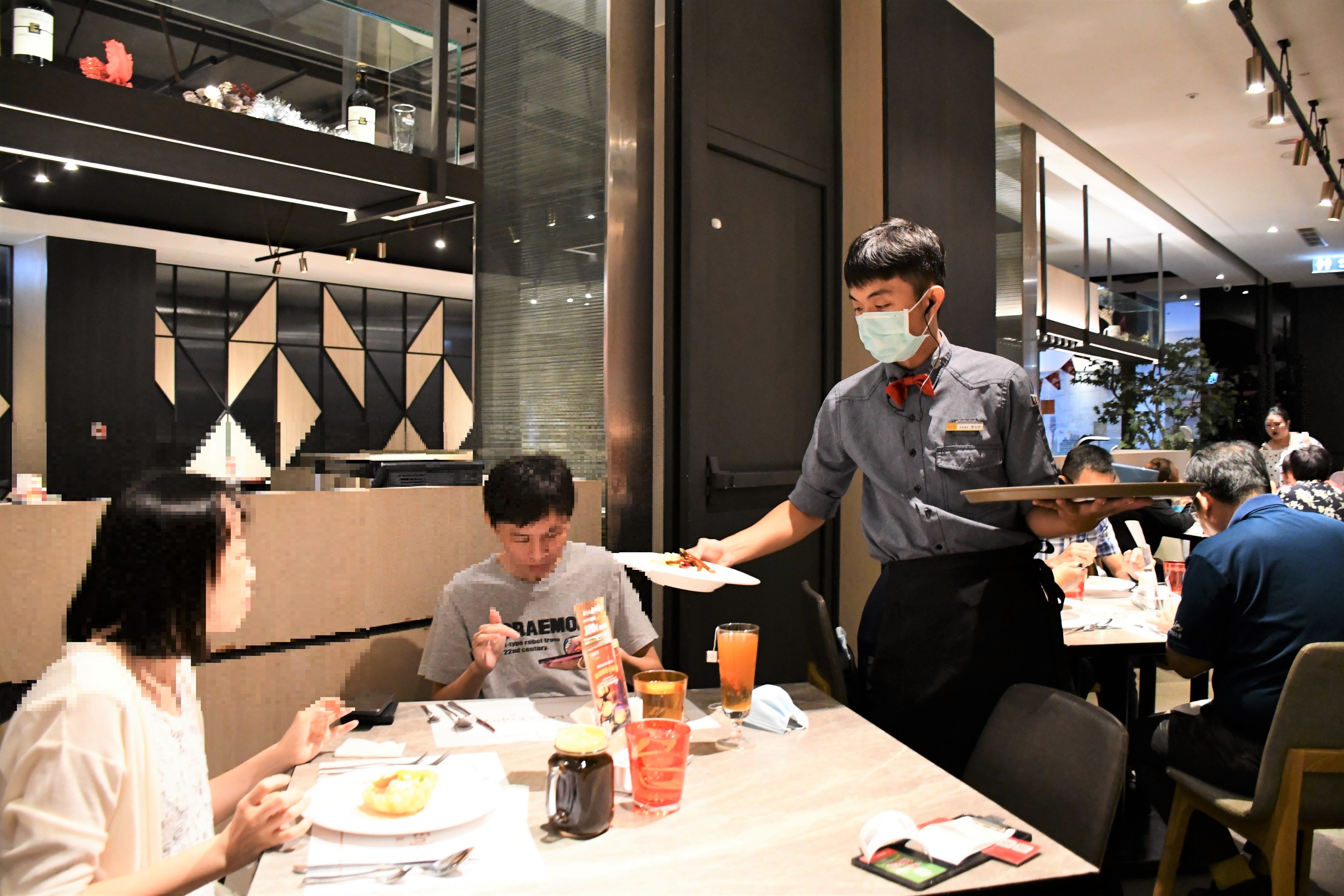 郭言伊目前擔任西堤斗六店的大廳見習襄理(右)，透過領航計畫職場導師的工作崗位訓練，已可獨當一面服務顧客。