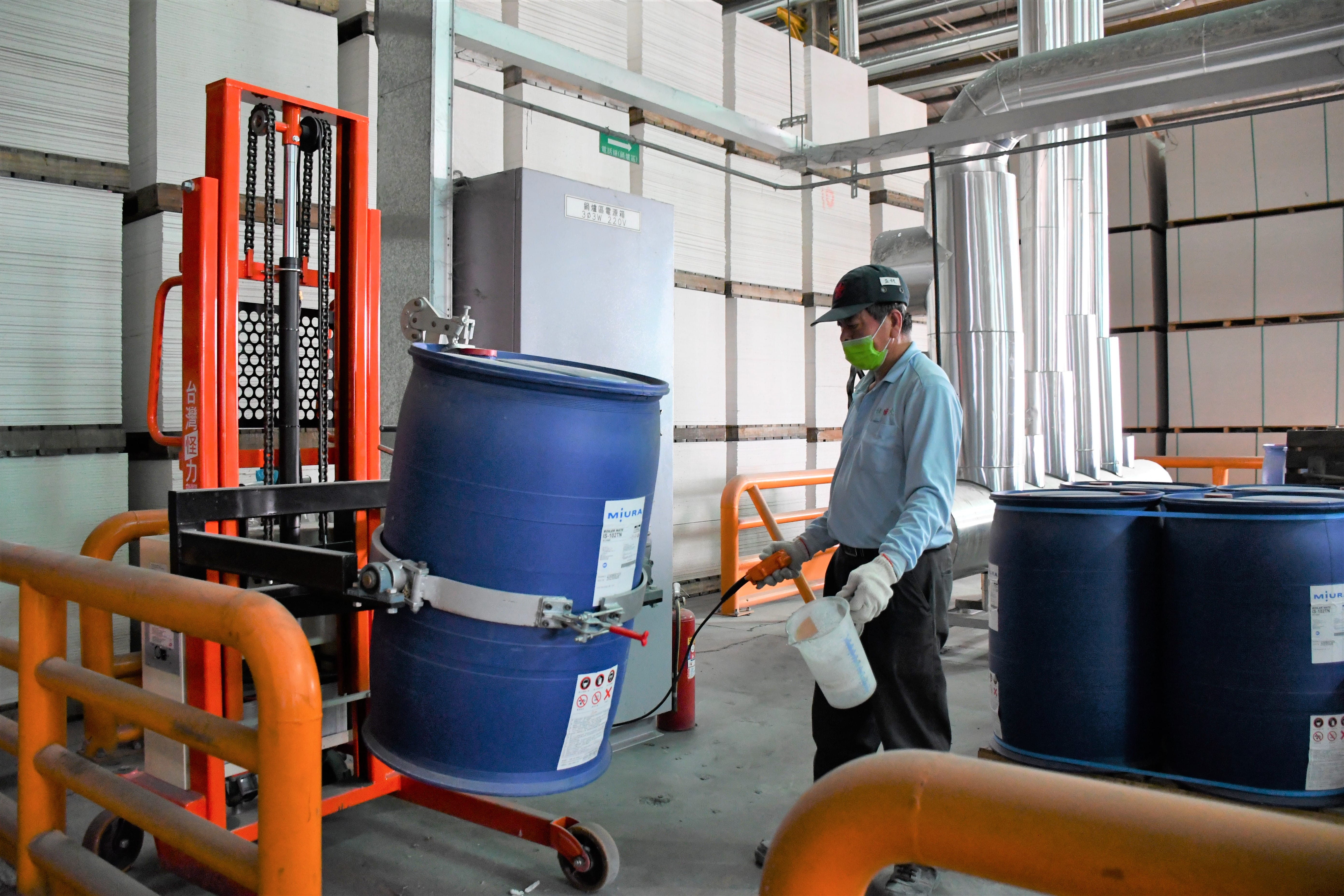 佳大建材公司產線人員透過勞動部「中高齡職務再設計」增購電動油桶傾倒料機，改善以往需反覆抬舉油桶的作業方式。