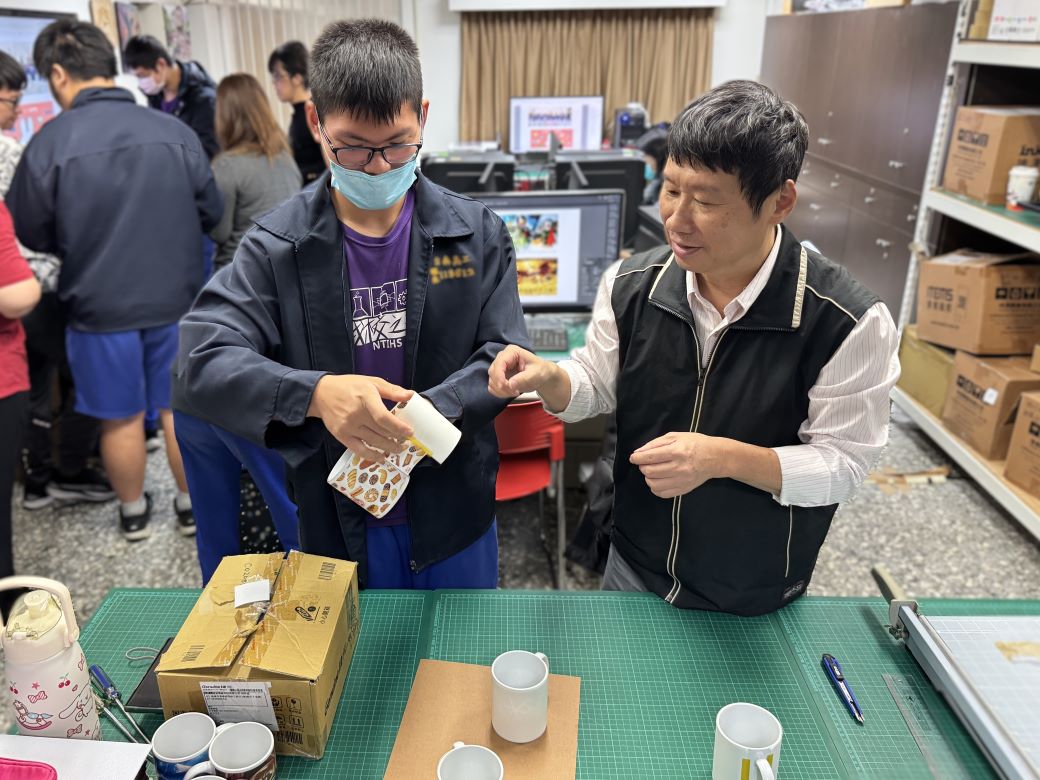圖2.南分署職訓師郭文軒(右)指導學員卸除馬克杯轉印圖案。